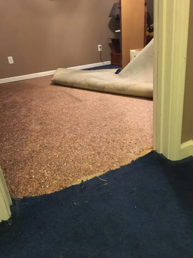 Carpet pad removal revealing water damage during Water Mitigation Services in Prairieville